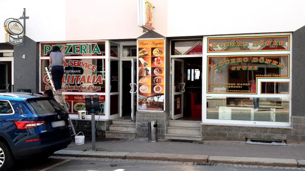 Bunte Schaufensterfront mit zwei Eingängen Pizzeria und Dönerladen